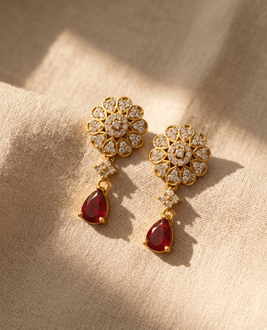 pair-of-traditional-gold-plated-earrings-featuring-a-cz-paved-floral-stud-and-a-vibrant-ruby-red-pear-shaped-teardrop-pendant