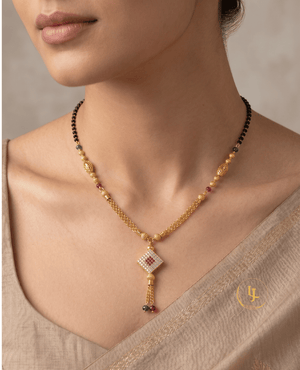 Landmark Jewels gold-plated mangalsutra with a square diamond-studded pendant, ruby and emerald beads, filigree gold globes, and a double-chain tassel finish.