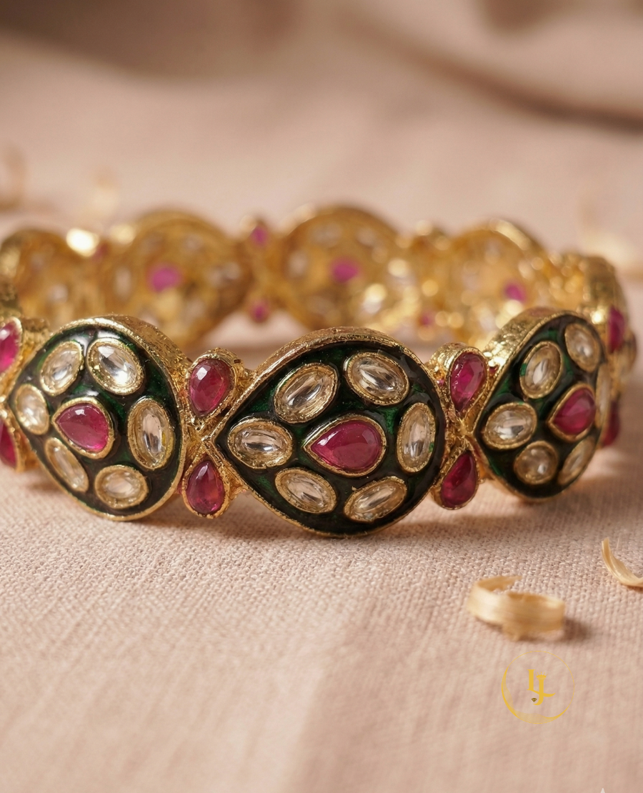 pair-of-gold-plated-indian-bangles-with-ruby-stones-white-polki-crystals-and-black-enamel-work-on-a-floral-background