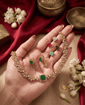 Landmark Jewels interchangeable jewelry set held in hand showing various colored square gemstones including ruby, mint, and white.