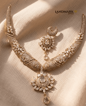Landmark Jewels American Diamond gold-toned choker necklace and earring set with intricate floral stone patterns on a textured fabric background.