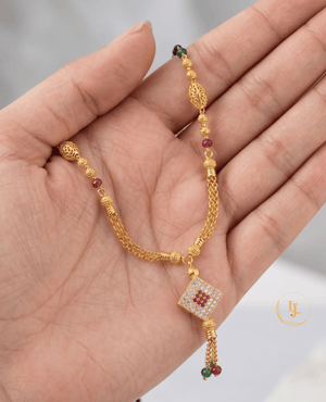 Landmark Jewels gold-plated mangalsutra with a square diamond-studded pendant, ruby and emerald beads, filigree gold globes, and a double-chain tassel finish.