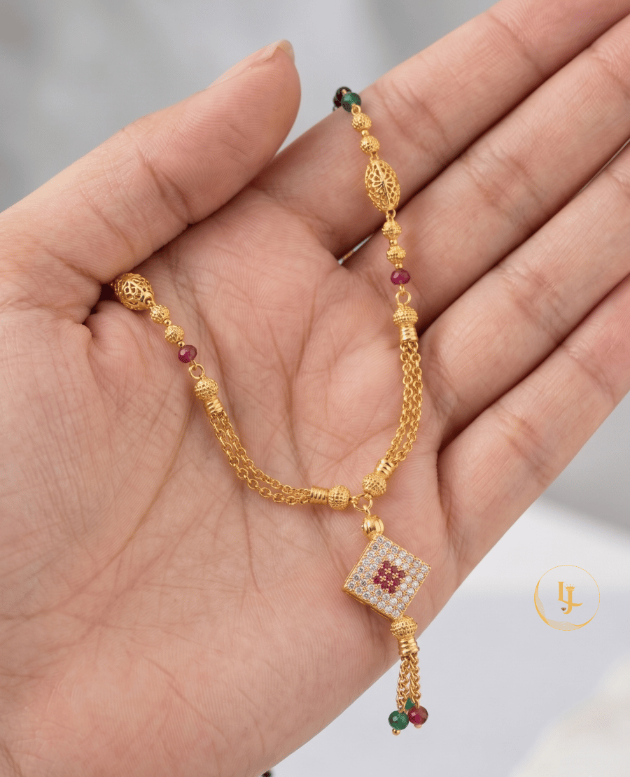 landmark-jewels-gold-plated-mangalsutra-with-a-square-diamond-studded-pendant-ruby-and-emerald-beads-filigree-gold-globes-and-a-double-chain-tassel-finish