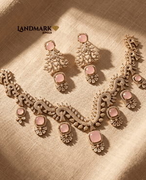 Landmark Jewels pink rose quartz and American Diamond choker necklace with matching chandelier earrings on a beige textured background.