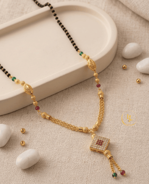 Landmark Jewels gold-plated mangalsutra with a square diamond-studded pendant, ruby and emerald beads, filigree gold globes, and a double-chain tassel finish.