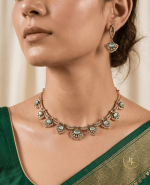 Close-up of a model wearing Landmark Jewels' sea-foam pastel stone choker and matching drop earrings paired with a green silk saree.