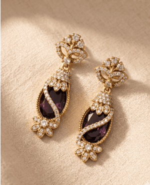 Elegant long drop earrings by Landmark Jewels featuring dark purple oval stones wrapped in crystal-encrusted gold ribbons.