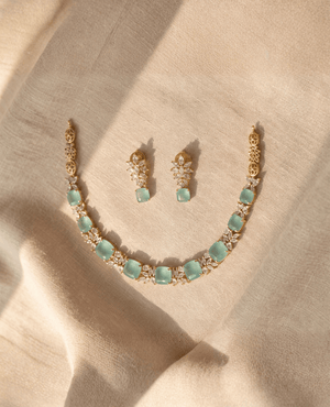 Gold necklace featuring square mint green Monalisa stones and sparkling crystal clusters, accompanied by matching drop earrings.