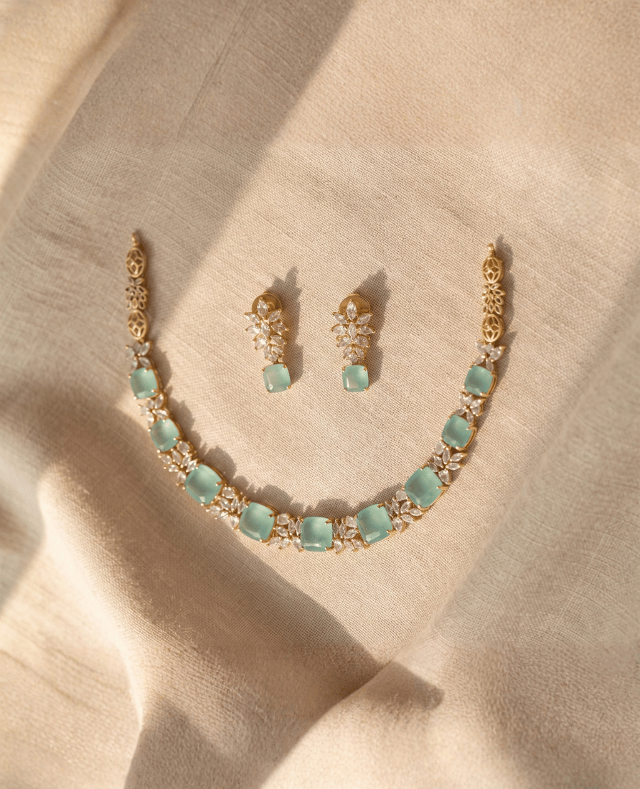 gold-necklace-featuring-square-mint-green-monalisa-stones-and-sparkling-crystal-clusters-accompanied-by-matching-drop-earrings
