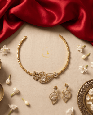 Flat lay view of Landmark Jewels asymmetrical crystal necklace and matching teardrop earrings on a beige background.