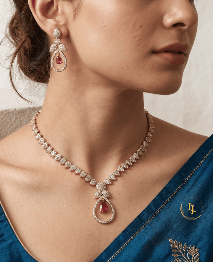Close-up of a woman wearing the Landmark Jewels rose gold necklace and matching teardrop earrings with a blue saree.