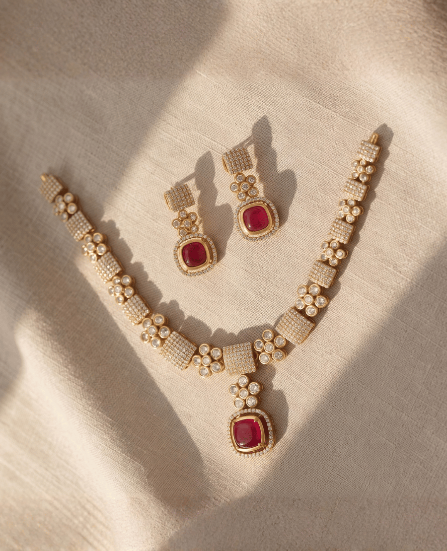 gold-necklace-with-paved-crystal-blocks-and-a-vibrant-square-ruby-red-stone-pendant-alongside-matching-cushion-cut-ruby-earrings