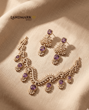 Landmark Jewels imitation gold necklace and earring set with purple cushion-cut stones and white cubic zirconia on a beige fabric background.