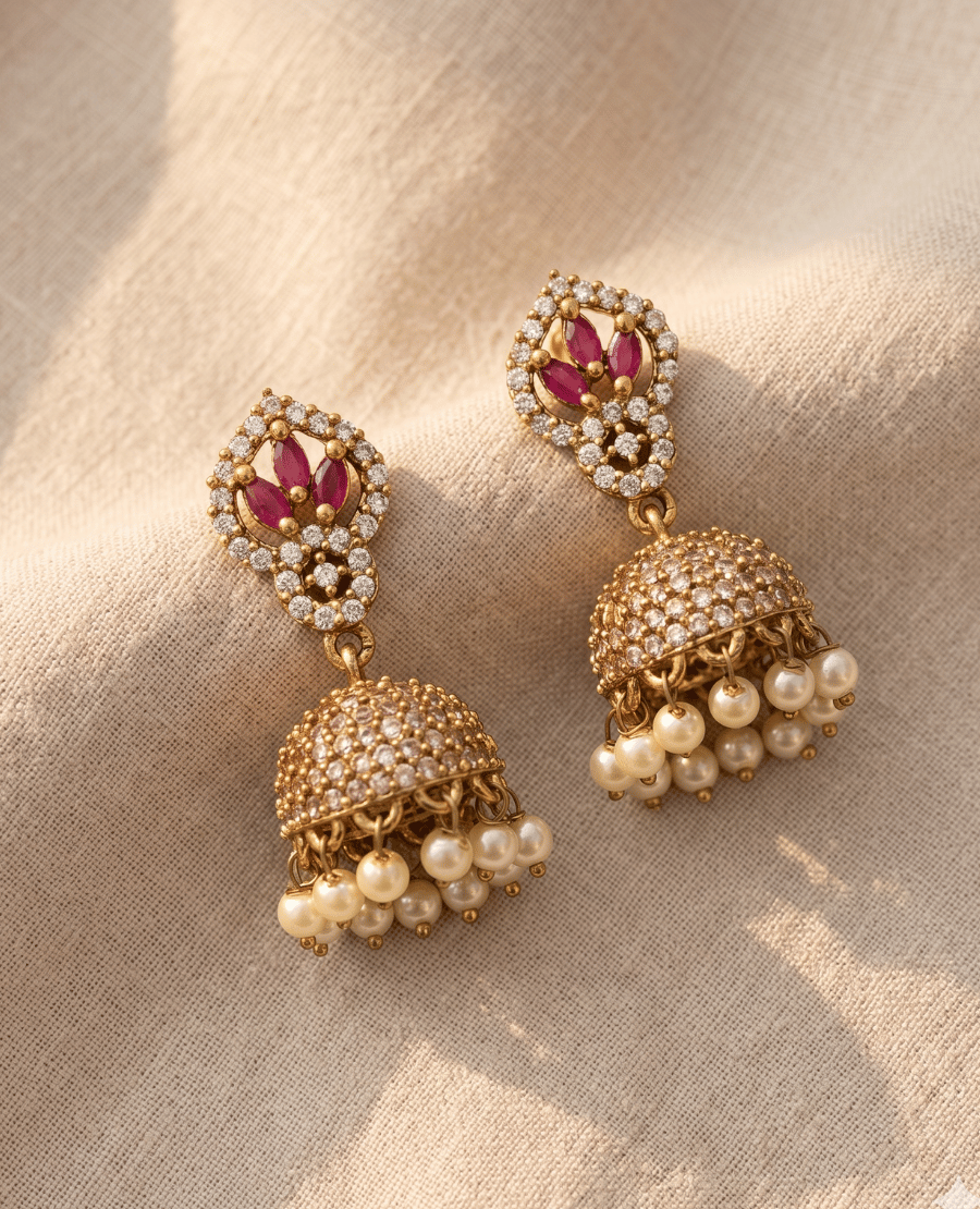 designer-gold-plated-jhumkas-featuring-a-diamond-shaped-stud-with-marquise-ruby-stones-and-a-dense-cz-studded-dome-with-pearl-fringes