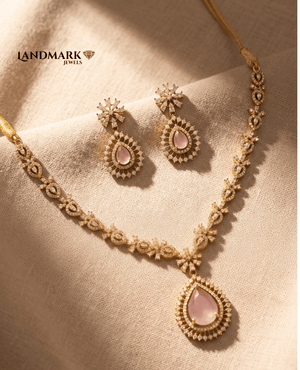 Landmark Jewels rose pink teardrop pendant necklace and matching drop earrings featuring crystal-encrusted floral details on a gold-toned finish.