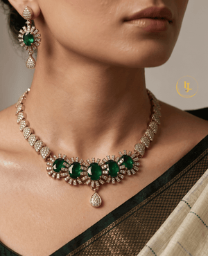 Close-up of a model wearing Landmark Jewels emerald sunburst choker and matching earrings with a traditional saree.