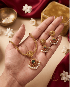 Landmark Jewels gold-plated temple jewelry set held in hand showing the scale and intricate Goddess Lakshmi engraving.
