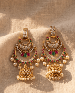 Elegant large crescent moon imitation gold earrings from Landmark Jewels studded with white stones, ruby-emerald teardrops, and a dangling pearl jhumka.
