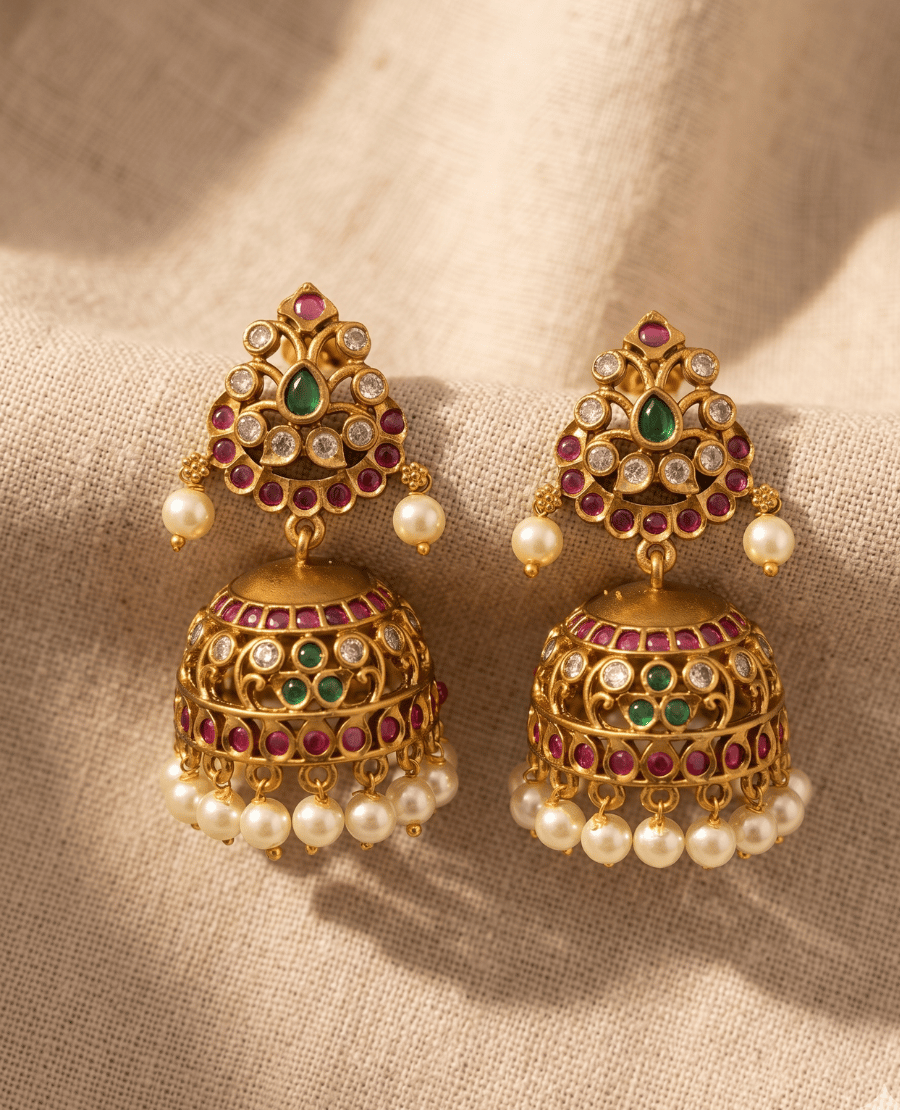 traditional-matte-gold-plated-kundan-jhumka-earrings-by-landmark-jewels-featuring-intricate-stone-floral-work-ruby-and-emerald-centers-and-a-fringe-of-white-faux-pearls