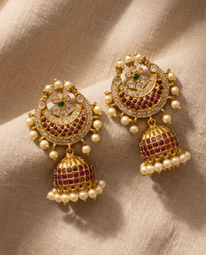Royal gold Chandbali Jhumka earrings encrusted with rows of square-cut ruby red stones and finished with a striking perimeter of small white pearls.