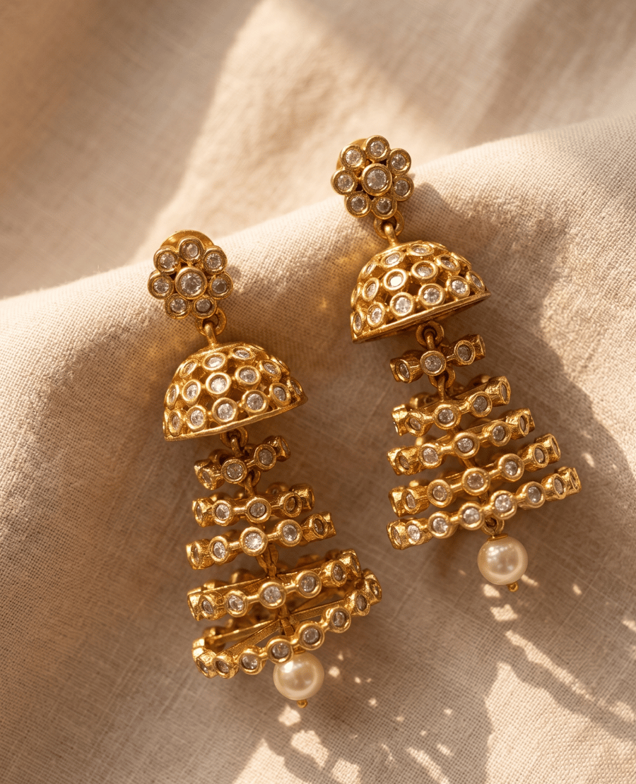bold-tiered-chandelier-style-gold-plated-jhumka-earrings-covered-in-clear-cubic-zirconia-crystals-with-a-hanging-pearl