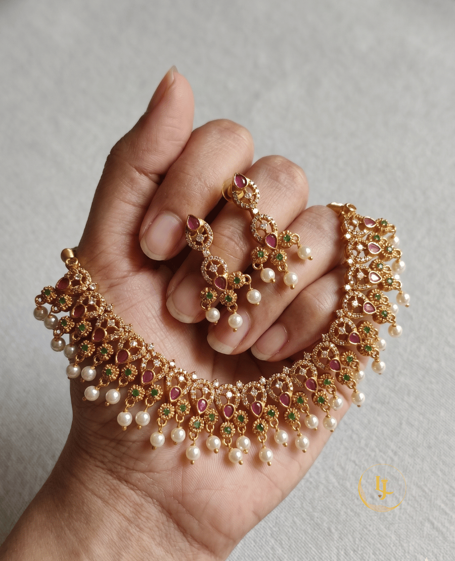 landmark-jewels-imitation-necklace-set-featuring-teardrop-rubies-and-green-emerald-stones-held-in-hand-to-show-scale
