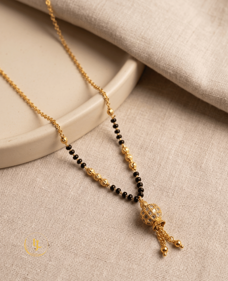 landmark-jewels-modern-gold-plated-mangalsutra-featuring-a-stone-studded-globe-pendant-with-gold-tassels-and-a-delicate-black-bead-chain