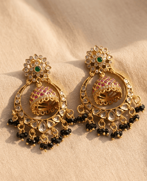Landmark Jewels traditional gold-plated chandbali earrings featuring a central ruby-studded jhumka, intricate Kundan work, a green stone stud, and black bead hangings.