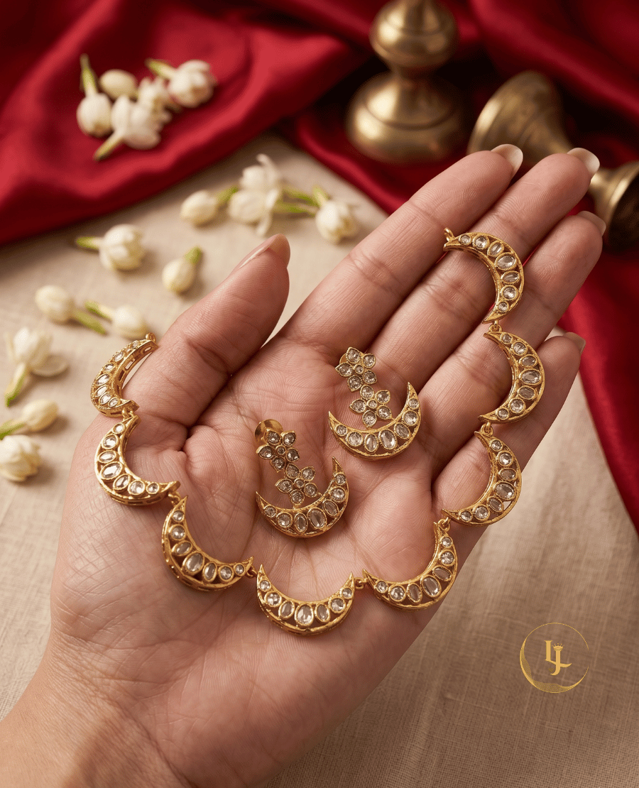 a-hand-holding-a-celestial-inspired-gold-necklace-with-white-kundan-stone-moon-charms-and-matching-earrings