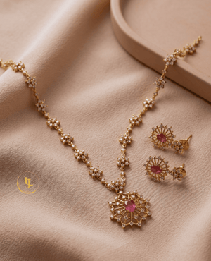 Flatlay view of Aurora ruby-pink imitation jewelry set on a beige fabric background by Landmark Jewels.