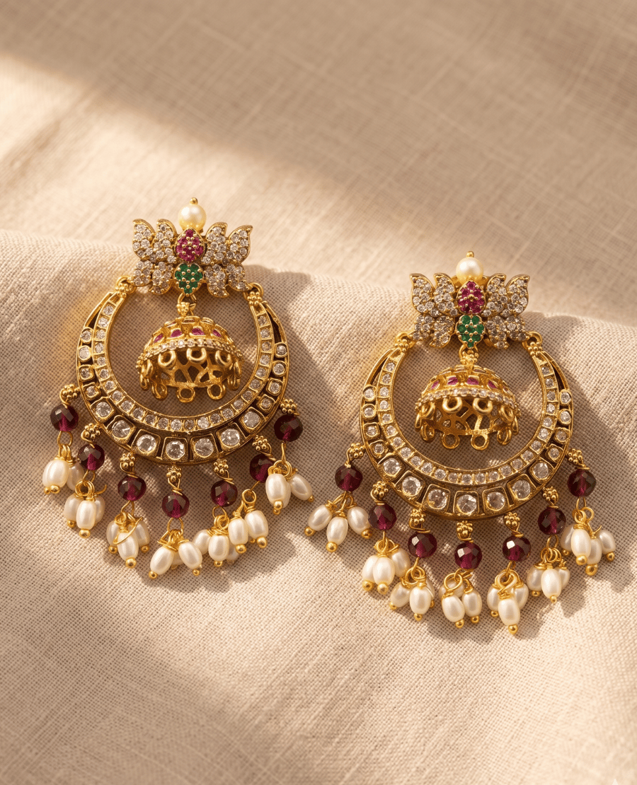 pair-of-traditional-indian-gold-plated-chandbali-jhumka-earrings-by-landmark-jewels-featuring-intricate-stone-studs-a-central-gold-jhumka-and-hanging-pearl-and-maroon-bead-drops-on-a-beige-linen-background