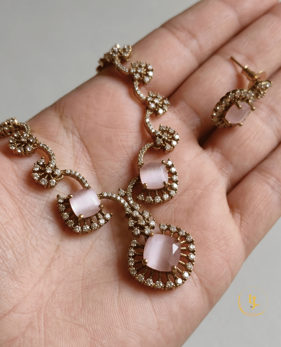 handheld-view-of-the-pink-cats-eye-floral-necklace-by-landmark-jewels-showing-the-intricate-rose-gold-craftsmanship