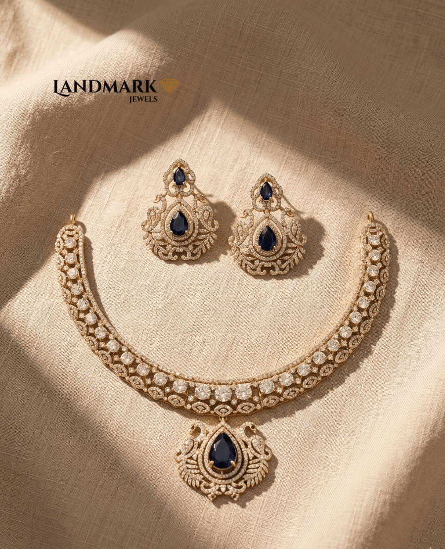 landmark-jewels-gold-plated-necklace-set-featuring-pear-cut-blue-sapphire-stones-and-white-cz-diamonds-on-a-beige-fabric-background