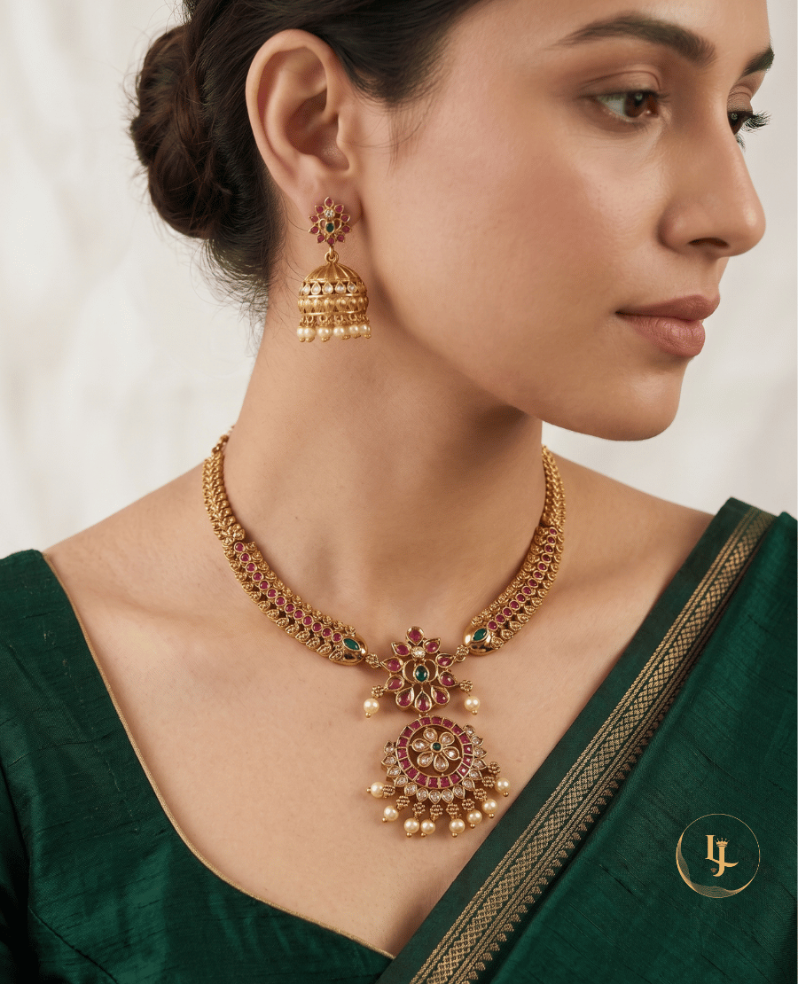 model-wearing-landmark-jewels-antique-gold-necklace-with-ruby-kemp-stones-and-matching-jhumka-earrings-on-a-green-saree