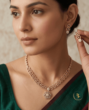 Indian model showcasing Landmark Jewels gold-plated necklace with circular links and floral pendant paired with a green saree.