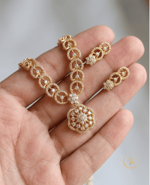 Detailed close-up of Landmark Jewels imitation diamond necklace and earrings featuring intricate CZ stone settings in gold plating.