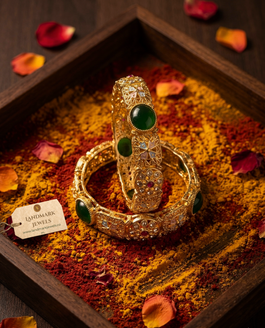 antique-gold-plated-bangles-with-emerald-green-stones-and-floral-meenakari-design-on-a-traditional-festive-background