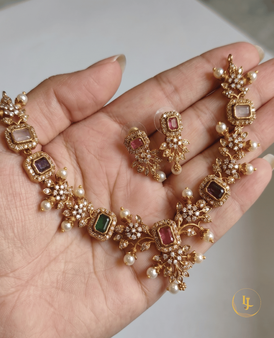 hand-held-view-showing-the-intricate-floral-detail-and-pearl-droplets-of-the-landmark-jewels-navratna-style-imitation-necklace