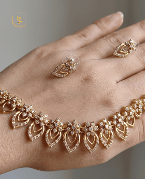 Detailed view of the Landmark Jewels necklace and matching stud earrings held in hand to showcase the scale and stone craftsmanship.