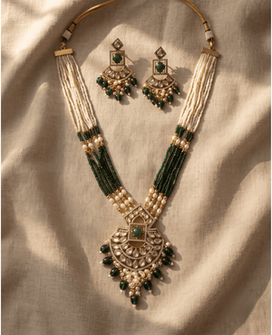 Layered white and green bead necklace featuring an intricate semi-circular Polki pendant and matching statement earrings.