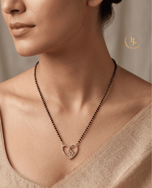 Landmark Jewels gold-plated mangalsutra featuring a heart-shaped pendant studded with American diamonds and a floral motif on a black bead chain.