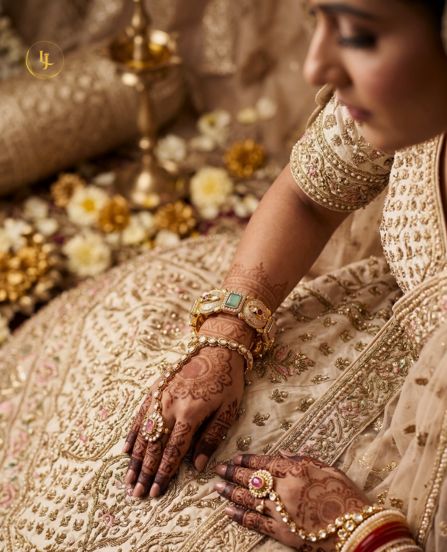 pair-of-gold-plated-indian-meenakari-bangles-with-ruby-and-emerald-stones-on-a-beige-fabric-background