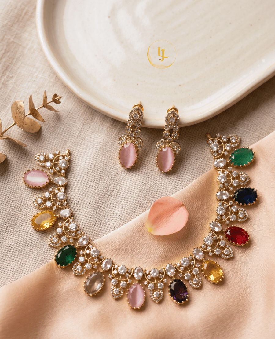 overhead-view-of-a-gold-finish-imitation-necklace-with-colorful-oval-stones-and-matching-earrings-displayed-on-a-cream-fabric-and-ceramic-plate