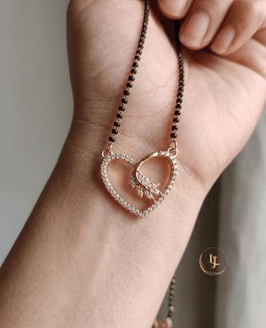 Landmark Jewels gold-plated mangalsutra featuring a heart-shaped pendant studded with American diamonds and a floral motif on a black bead chain.