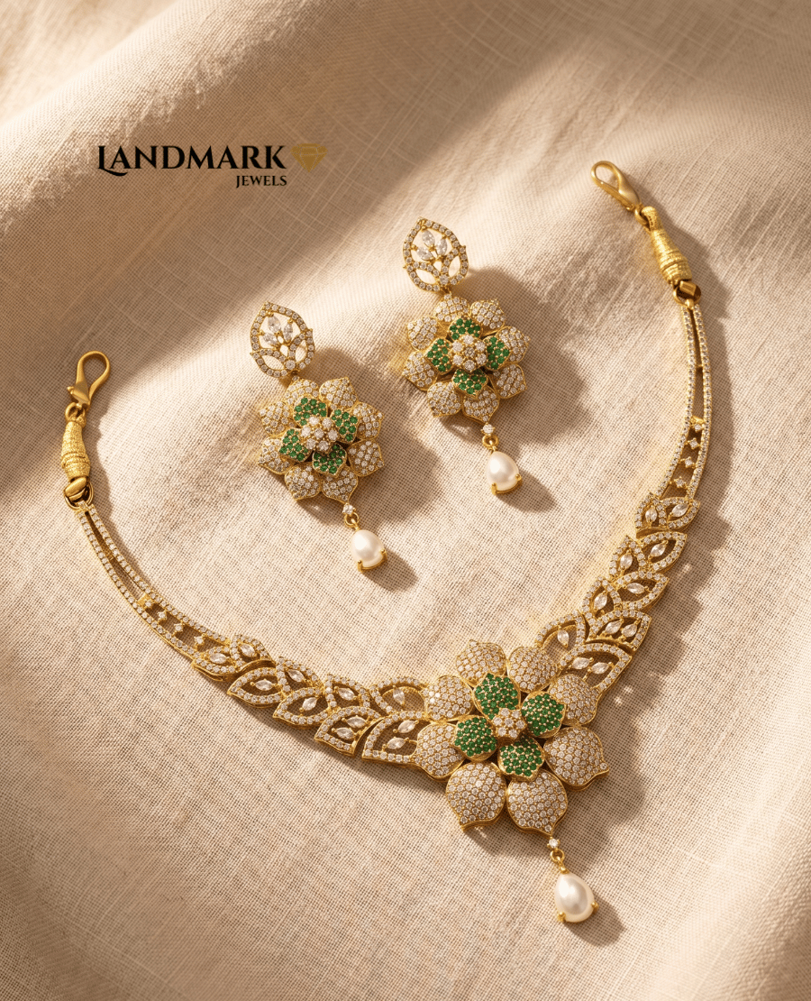 a-gold-toned-necklace-and-earring-set-featuring-green-and-white-floral-stone-designs-with-hanging-pearl-drops-by-landmark-jewels