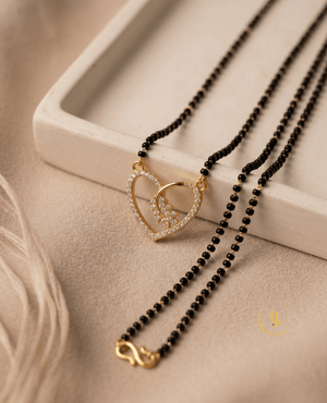 Landmark Jewels gold-plated mangalsutra featuring a heart-shaped pendant studded with American diamonds and a floral motif on a black bead chain.