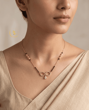 Landmark Jewels gold-plated mangalsutra featuring an infinity-shaped pendant with American Diamonds and a hanging pear-cut stone on a designer black bead chain.