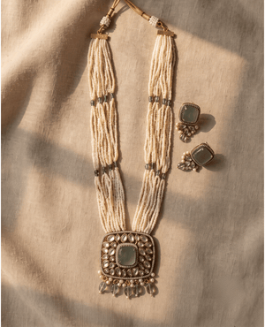 Multi-strand white seed bead long necklace with a square mint green stone and Polki pendant, plus matching square earrings.