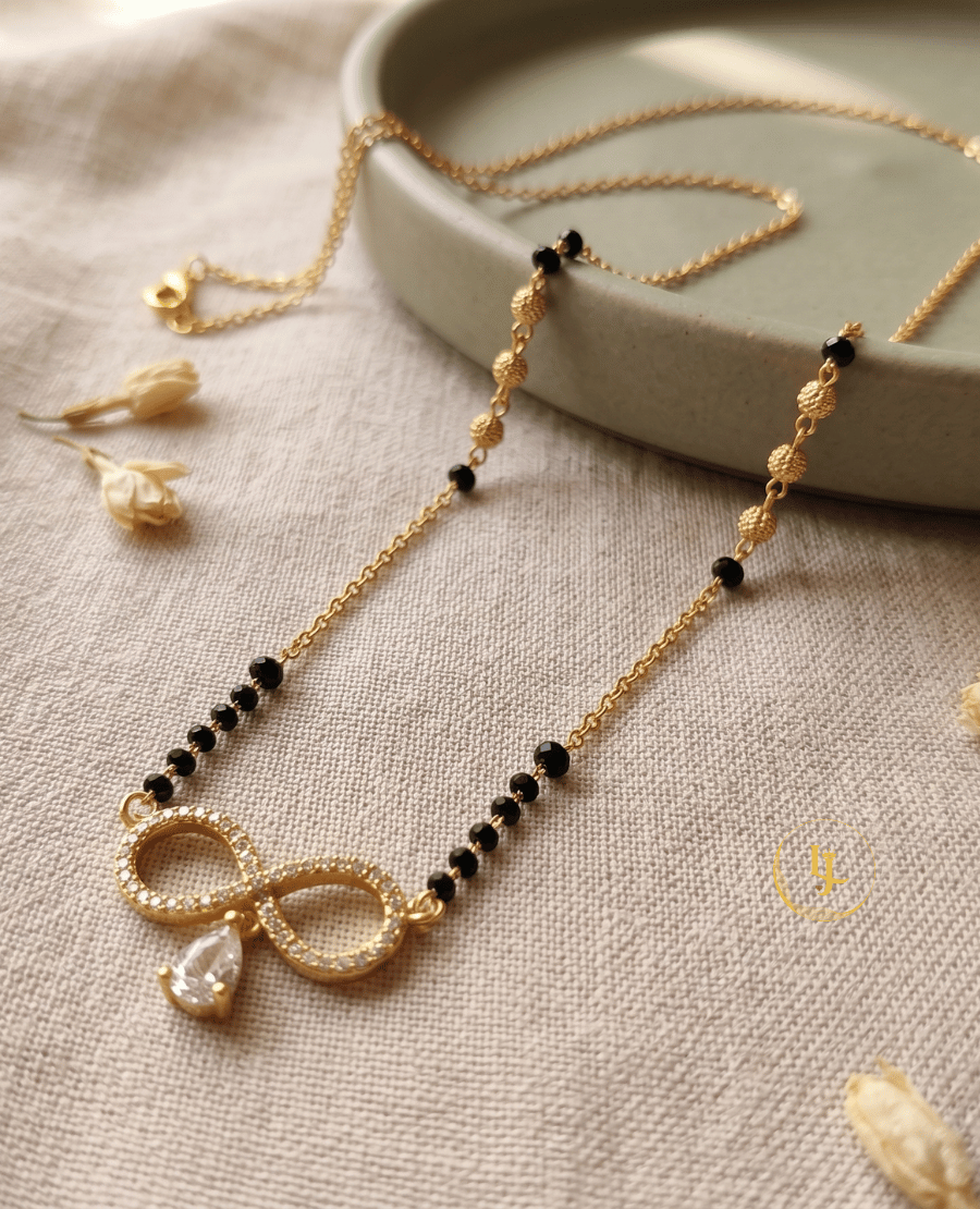 landmark-jewels-gold-plated-mangalsutra-featuring-an-infinity-shaped-pendant-with-american-diamonds-and-a-hanging-pear-cut-stone-on-a-designer-black-bead-chain