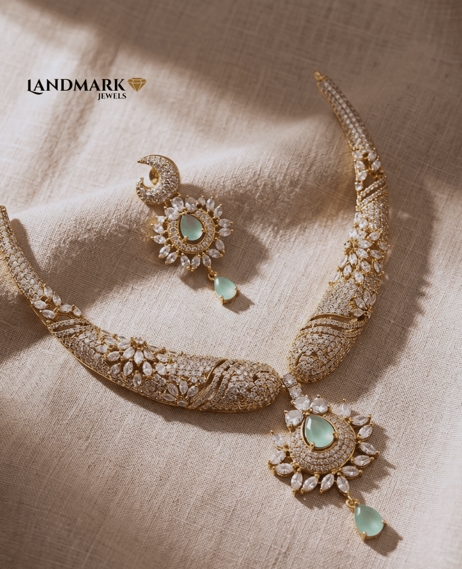 elegant-gold-toned-landmark-jewels-necklace-set-featuring-white-cubic-zirconia-floral-patterns-and-mint-green-teardrop-stones-on-a-beige-fabric-background